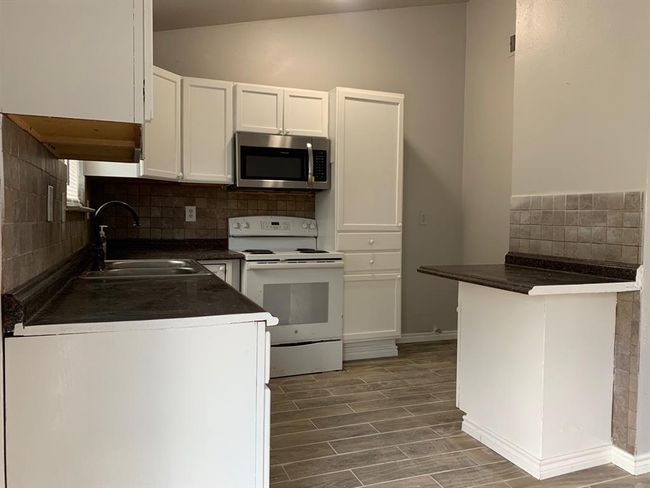 Kitchen featuring tasteful backsplash, white range with electric stovetop, sink, white cabinets, and lofted ceiling | Image 6