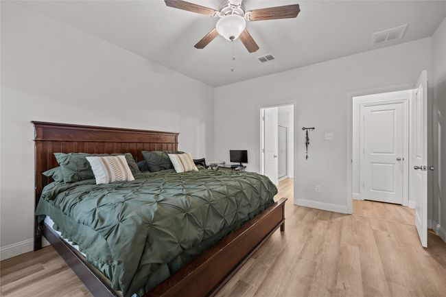 Bedroom with baseboards, light wood-style floors, and a ceiling fan | Image 18