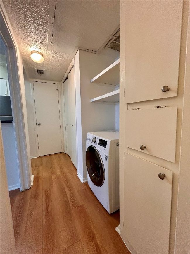 Laundry area with washer / clothes dryer, light wood-type flooring, and a textured ceiling | Image 6