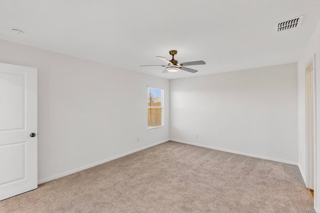 Empty room with a ceiling fan, carpet flooring, and baseboards | Image 15