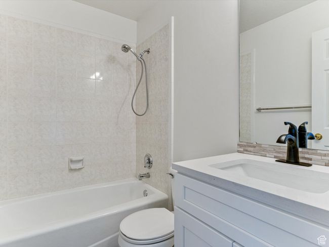 Bathroom featuring toilet, vanity, and shower / bathing tub combination | Image 11