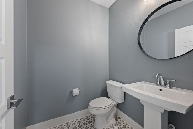 Bathroom with toilet, baseboards, a sink, and tile patterned floors | Image 23