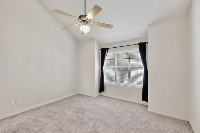 Empty room featuring vaulted ceiling, light carpet, and a ceiling fan | Image 29