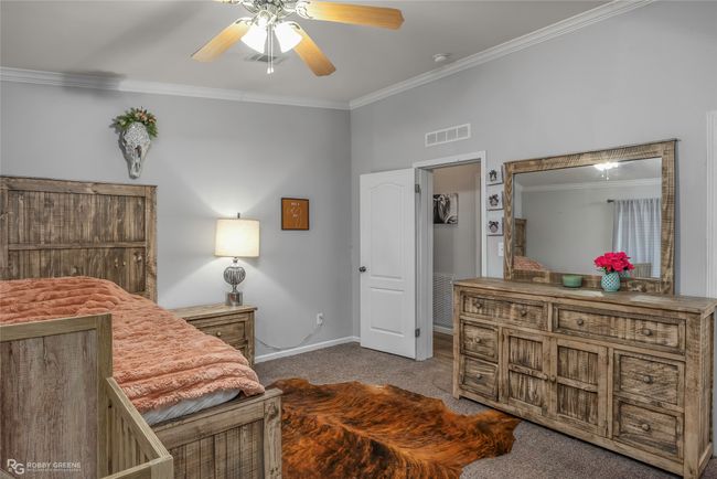 Carpeted bedroom with visible vents, ceiling fan, ornamental molding, and baseboards | Image 26