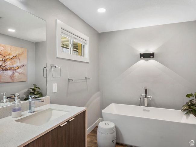 Full bathroom featuring a freestanding bath, wood finished floors, vanity, and recessed lighting | Image 27
