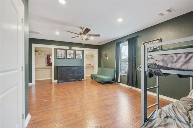 Bedroom with wood finished floors, recessed lighting, a walk in closet, and ceiling fan | Image 23