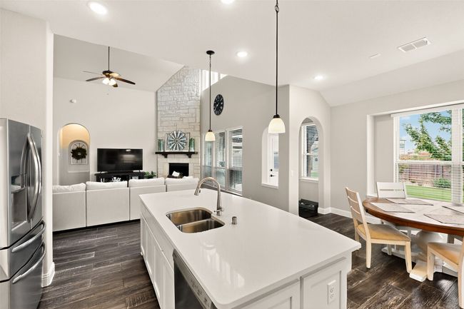 Kitchen with stainless steel appliances, a sink, ceiling fan, dark wood-style floors, and recessed lighting | Image 11