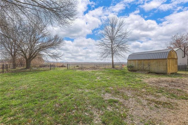 View of yard featuring a rural view, fence, a storage shed, and an outdoor structure | Image 7