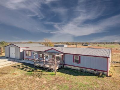 Manufactured / mobile home with a front lawn, a rural view, an outdoor structure, and a garage | Image 2