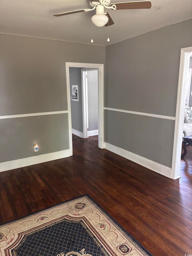 Empty room with a ceiling fan, wood finished floors, and baseboards | Image 14