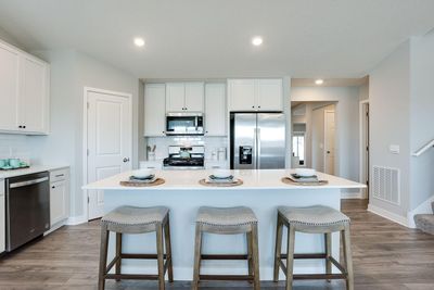 Open kitchen with excellent lighting and quality finishes. The smart layout in the Finnegan kitchen also features a window above the kitchen sink. Photo of Model Home. Options and colors may vary. Ask Sales Agent for details. | Image 3