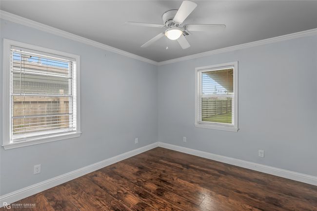 Unfurnished room with dark wood-type flooring, a healthy amount of sunlight, crown molding, and baseboards | Image 14