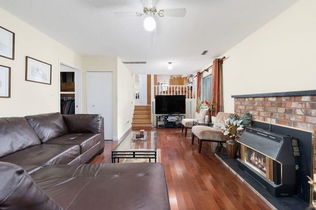 Living room with visible vents, ceiling fan, and wood finished floors | Image 13