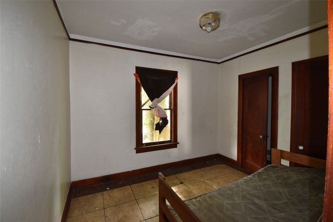 Bedroom with tile patterned floors and crown molding | Image 9