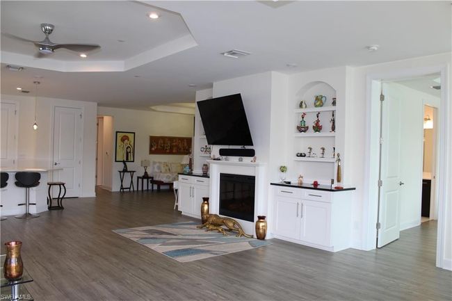 Living room featuring a raised ceiling, ceiling fan, dark wood finished floors, and visible vents | Image 9