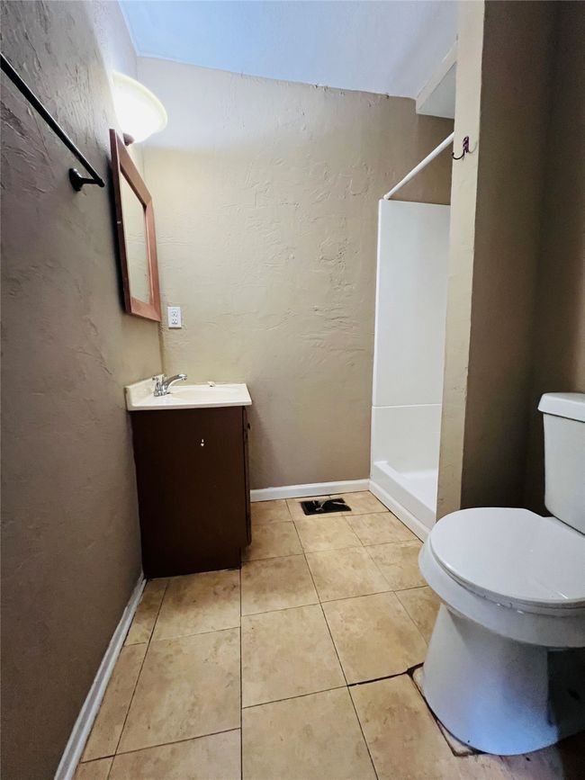 Bathroom featuring vanity, a shower, tile patterned flooring, and a textured wall | Image 20