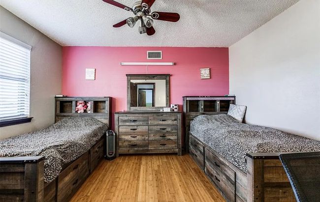 Bedroom featuring a textured ceiling and light wood finished floors | Image 12