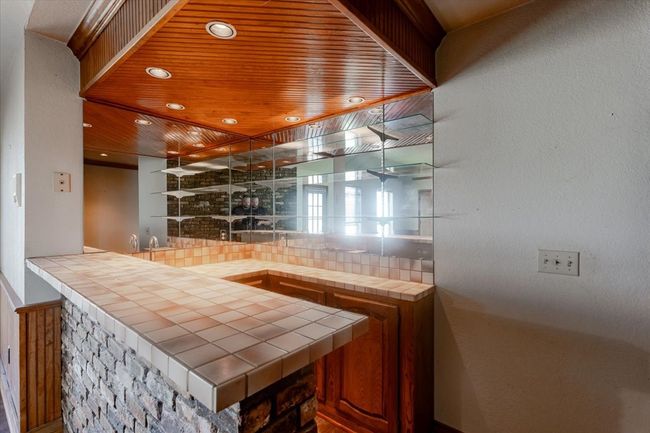 Enjoy entertaining with this full bar complete with ice maker. and sink, located just off of the game room which opens into the living room. This home was made to entertain! | Image 7