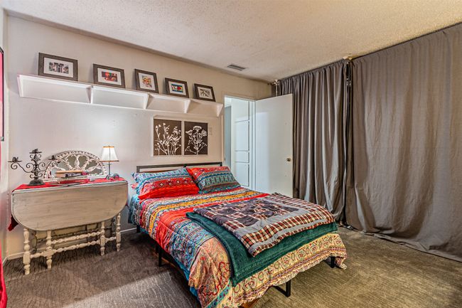 Carpeted bedroom featuring a textured ceiling | Image 14