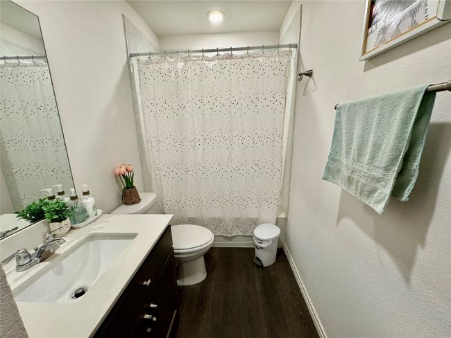 Full bath with wood finished floors, toilet, vanity, baseboards, and a shower with shower curtain | Image 13