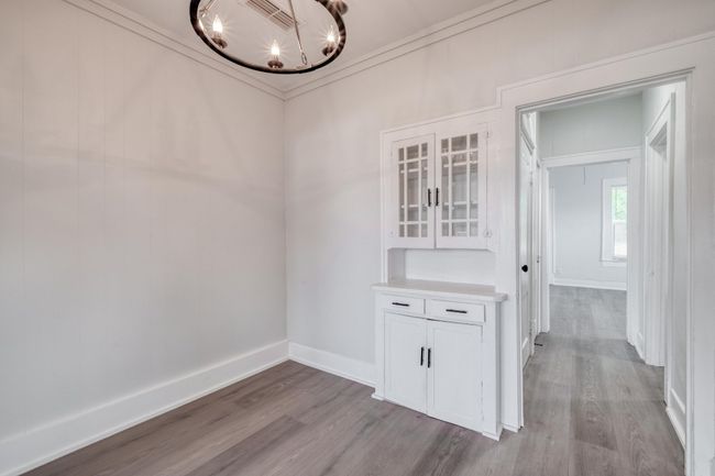 Unfurnished dining area with a chandelier and wood finished floors | Image 30