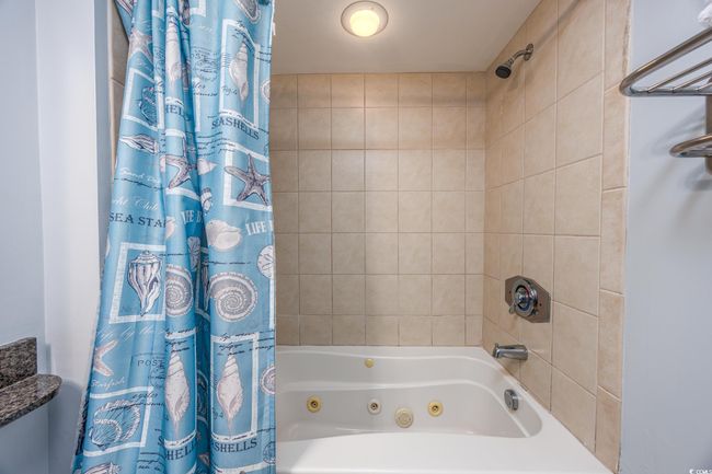 Bathroom featuring a combined bath / shower with jetted tub | Image 13