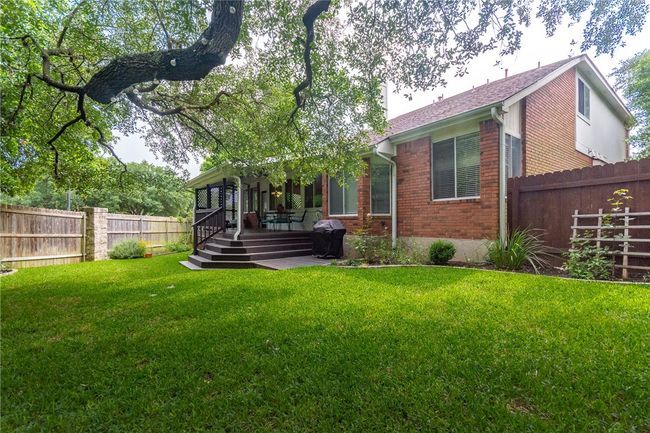 Rear view of property featuring brick siding and a fenced backyard | Image 29