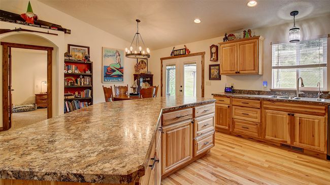 Kitchen featuring a sink, vaulted ceiling, light wood finished floors, hanging light fixtures, and recessed lighting | Image 7