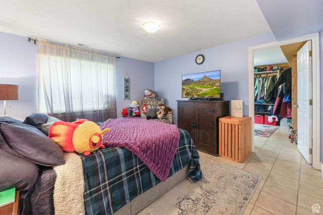 Bedroom featuring light tile patterned floors, a spacious closet, and visible vents | Image 31