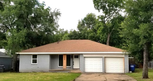 View of front of property featuring a garage, driveway, a front lawn, and a porch | Image 36