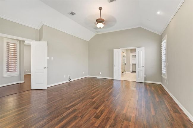 Double door entrance to the bedroom, high ceilings, neutral paint, crown molding and updated flooring. | Image 23