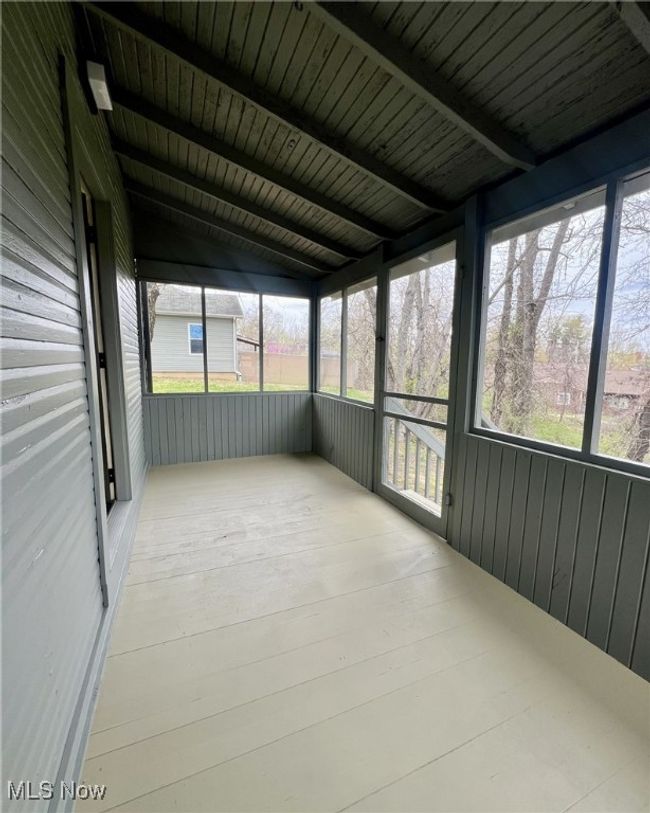 Unfurnished sunroom with beamed ceiling and a wealth of natural light | Image 13