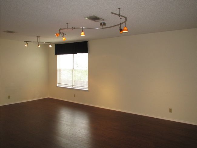 Spare room with dark wood-style floors, a textured ceiling, and rail lighting | Image 8