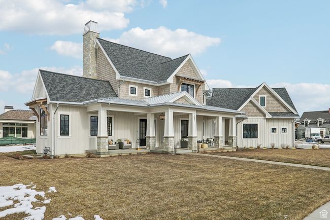 View of front of home with a porch, board and batten siding, a shingled roof, and a front yard | Image 53