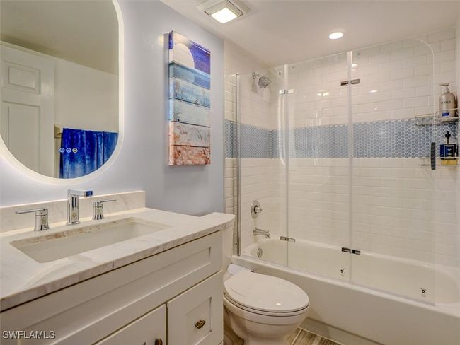 GUEST BATH W/MARBLE-TOPPED VANITY, ANTI-FOG BACKLIT MIRROR. COMBO TUB/SHOWER W/GLASS DOORS AND FULL-HEIGHT TILED SHOWER WALLS. | Image 31