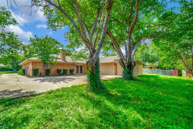 View of front of house featuring concrete driveway, brick siding, and a chimney | Image 5