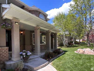 Doorway to property with a porch and a lawn | Image 2