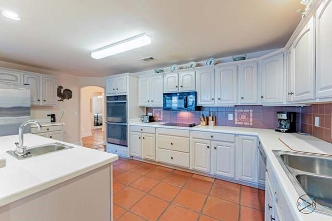 Kitchen offers plenty of cabinet space and room for cooking. | Image 6