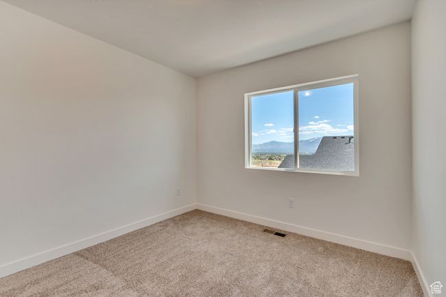 Spare room featuring baseboards, light carpet, and visible vents | Image 10