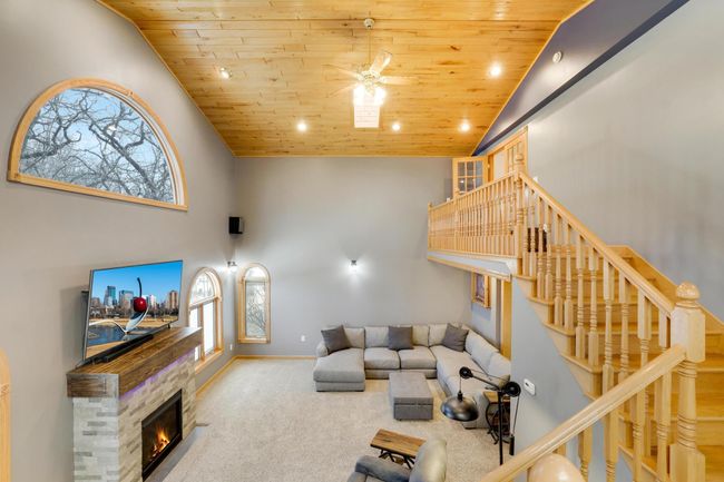 Be impressed by the soaring vaulted ceilings, huge windows and custom fireplace with storage in this beautiful great room. | Image 9