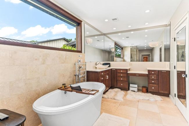 Full bath featuring tile walls, a freestanding tub, vanity, recessed lighting, and tile patterned floors | Image 21