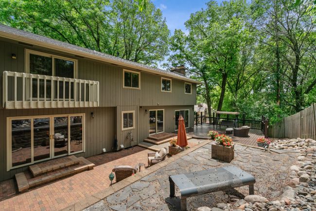 Private backyard oasis featuring tiered patios, lush wooded views, and multiple seating areas perfect for entertaining or relaxing outdoors. | Image 5