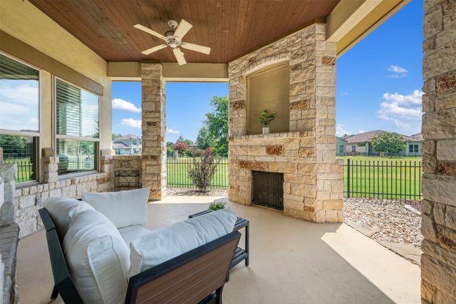 View of patio / terrace with a ceiling fan and an outdoor living space with a fireplace | Image 23
