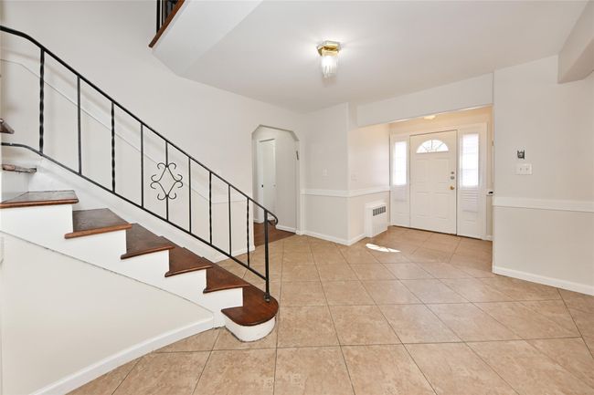 Entryway featuring baseboards, arched walkways, stairs, and light tile patterned flooring | Image 4