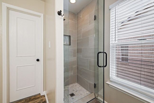 A recently remodeled walk-in shower with tile surround adds a spa-like touch to your daily routine. | Image 20