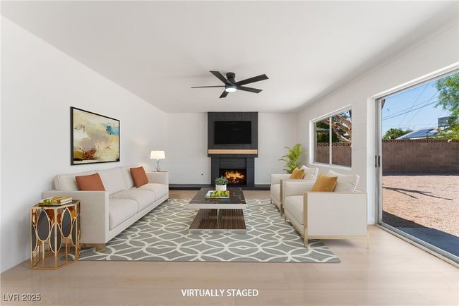 Living area featuring a large fireplace and a ceiling fan | Image 4