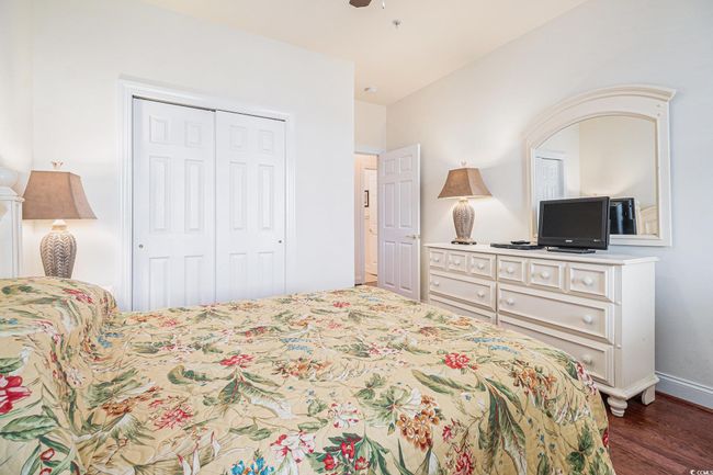Bedroom featuring a closet, dark wood-style flooring, a ceiling fan, and baseboards | Image 20