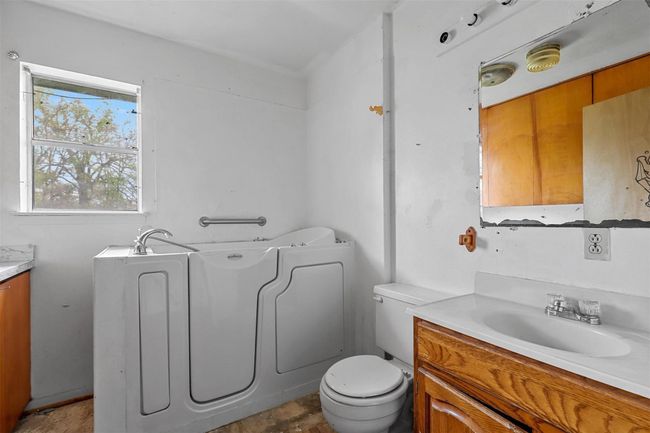 Bathroom with vanity, toilet, and a bathing tub | Image 6