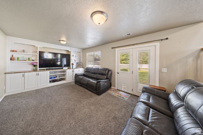 Living area featuring a textured ceiling and carpet flooring | Image 12
