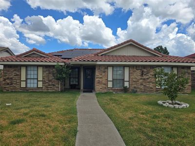 View of front of house featuring solar panels and a front yard | Image 1